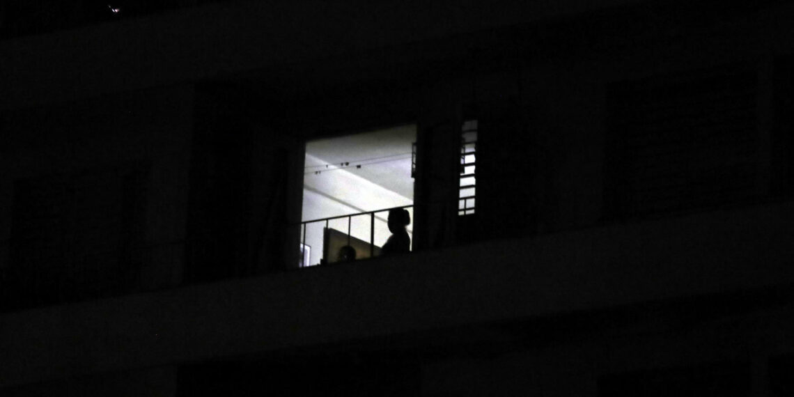 Fotografía de archivo de una mujer en su balcón durante un apagón, en La Habana (Cuba). EFE/Ernesto Mastrascusa