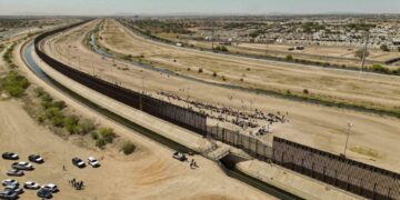 Fotografía aérea tomada ayer que muestra a cientos de migrantes junto al muro fronterizo en El Paso, Texas (EE.UU). EFE/ Jonathan Fernández