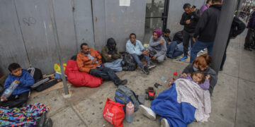 Migrantes de diferentes nacionalidades esperan en la entrada de la garita peatonal de San Ysidro para solicitar asilo a las autoridades estadounidenses, el 29 de mayo de 2023, en Tijuana (México). EFE/Joebeth Terríquez