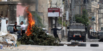 Palestinos tiran piedras a los soldados israelíes en enfrentamientos en el campo de refugiados de Balata en la ciudad de Nablus, en el norte de Cisjordania ocupada, territorio que vive su mayor pico de violencia desde la Segunda Intifada con 114 muertos en lo que va de año. EFE/Alaa Badarneh