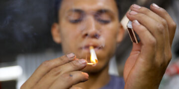 Un hombre enciende un cigarrillo hoy, en Tegucigalpa (Honduras). EFE/ Gustavo Amador