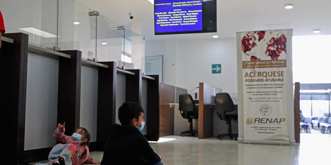 Niños observan la televisión mientras sus padres pasan por el proceso de entrada a Guatemala luego de ser deportados desde Texas, en una fotografía de archivo. EFE/Esteban Biba