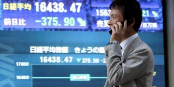 En la imagen de archivo, un hombre pasa delante de una pantalla que muestra el índice Nikkei de la Bolsa de Tokio. EFE/Everett Kennedy Brown