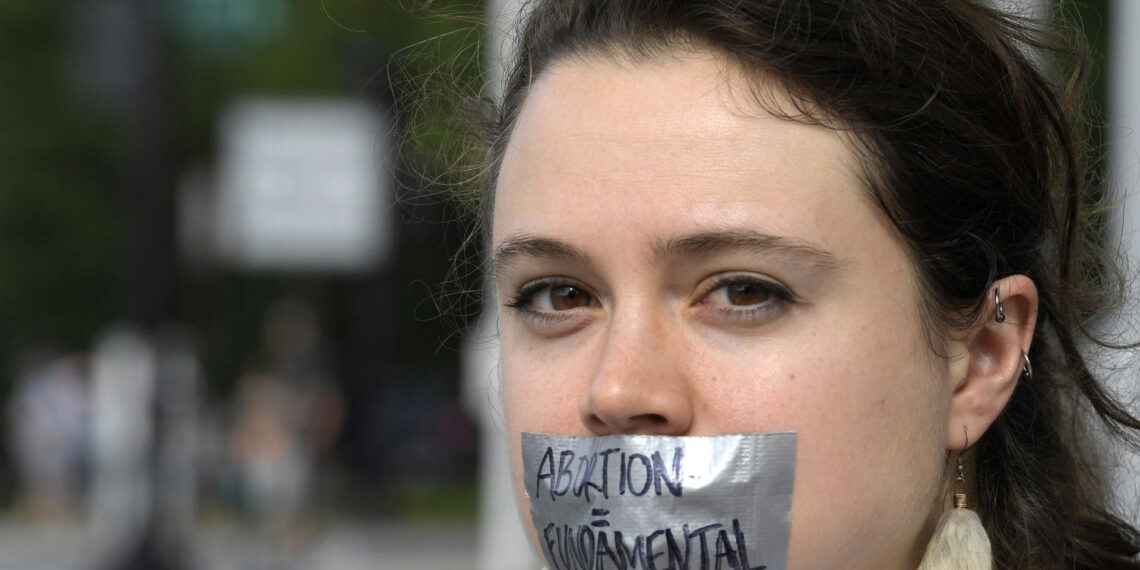 Fotografía de archivo en la que se registró a una mujer que al protestar se cubre la boca con una cinta que dice "Aborto es fundamental", en Washington DC (EE.UU.). EFE/Lenin Nolly