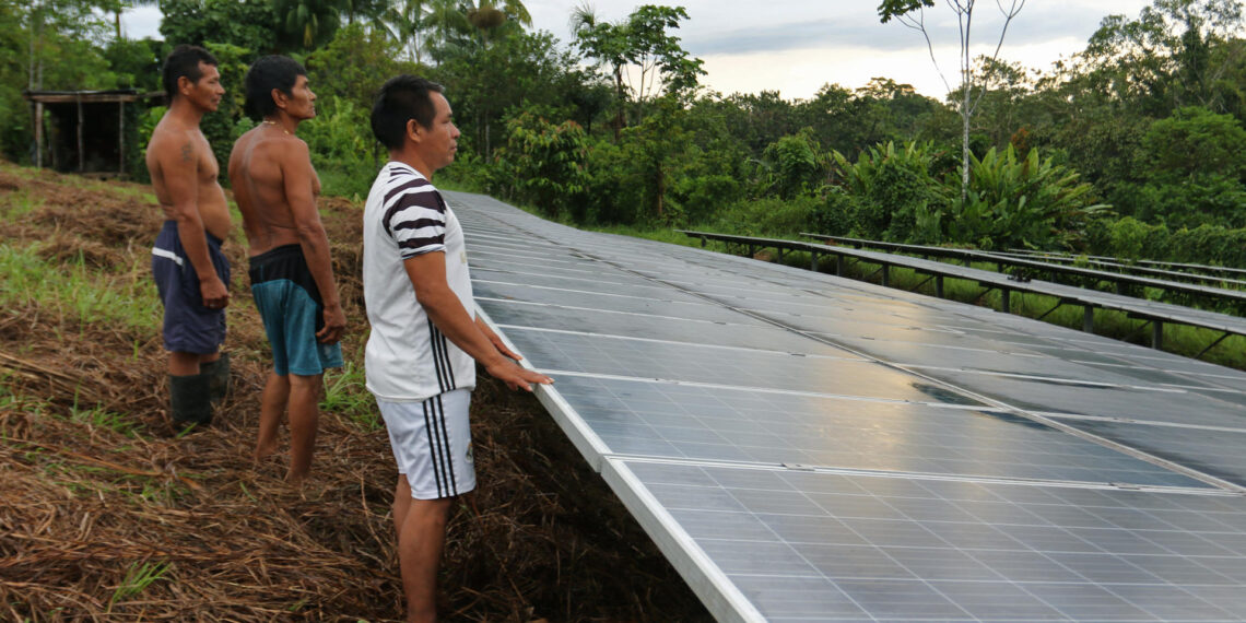 Líderes indígenas del caserío 20 de Julio posan junto a unos páneles solares sin funcionamiento, el 17 de abril de 2023, en Puerto Nariño, Amazonas (Colombia). EFE/Mario Baos