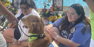 Una joven acaricia un perro de consuelo, el 24 de mayo de 2023, en la Plaza Uvalde (EE.UU.). EFE/Adam Davis