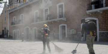 Empleados barren ceniza tras las continuas exhalaciones del volcán Popocatépetl hoy, en el municipio de Atlixco, Puebla (México). EFE/Hilda Ríos