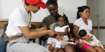 Un par de madres, con sus hijos en brazos, fueron registrados al ser atendidos en el centro sanitario de Pie de Pató, en el departamento del Chocó (Colombia). EFE/Juan Diego López