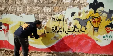 Un artista sirio dibuja mensajes de denuncia en la provincia de Idlib contra injusticias que ocurren en Siria. EFE/ Yahya Nemah
