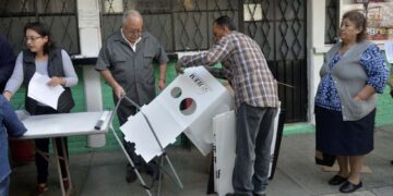 Funcionarios del IEEM preparan una casilla en Texcoco, para las elecciones en el Estado de México. PEDRO PARDO (AFP)