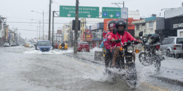 Dos motociclistas transitan por una calle inundada en Guayaquil (Ecuador). Foto de archivo. EFE/ Mauricio Torres