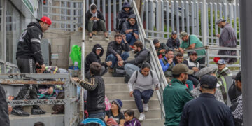 Migrantes de diferentes nacionalidades, descansan en la entrada de la garita peatonal de San Ysidro, hoy para solicitar asilo a las autoridades estadounidenses, en Tijuana (México). EFE/Joebeth Terríquez