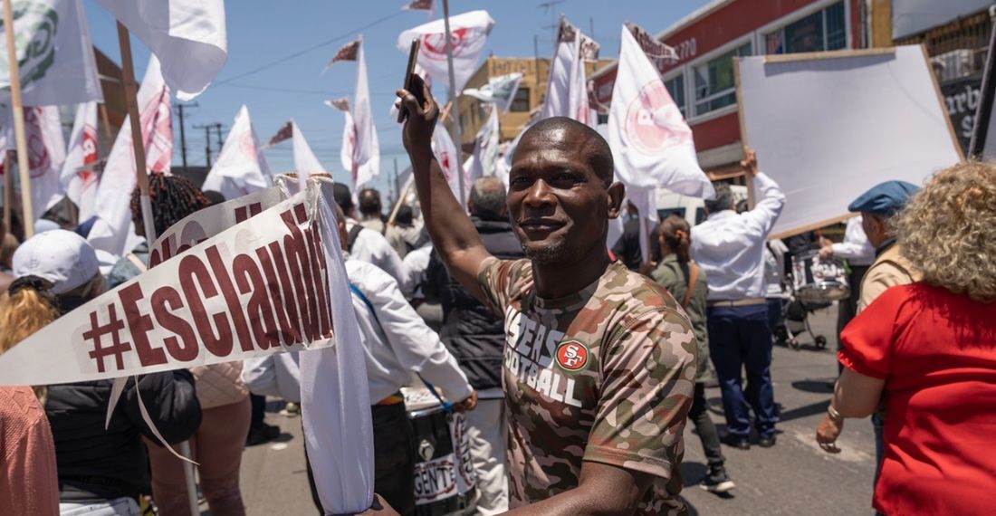 Los migrantes, en su gran mayoría haitianos, portaban banderines con la frase #EsClaudia, Foto: Aimee Melo/EL UNIVERSAL