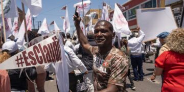 Los migrantes, en su gran mayoría haitianos, portaban banderines con la frase #EsClaudia, Foto: Aimee Melo/EL UNIVERSAL