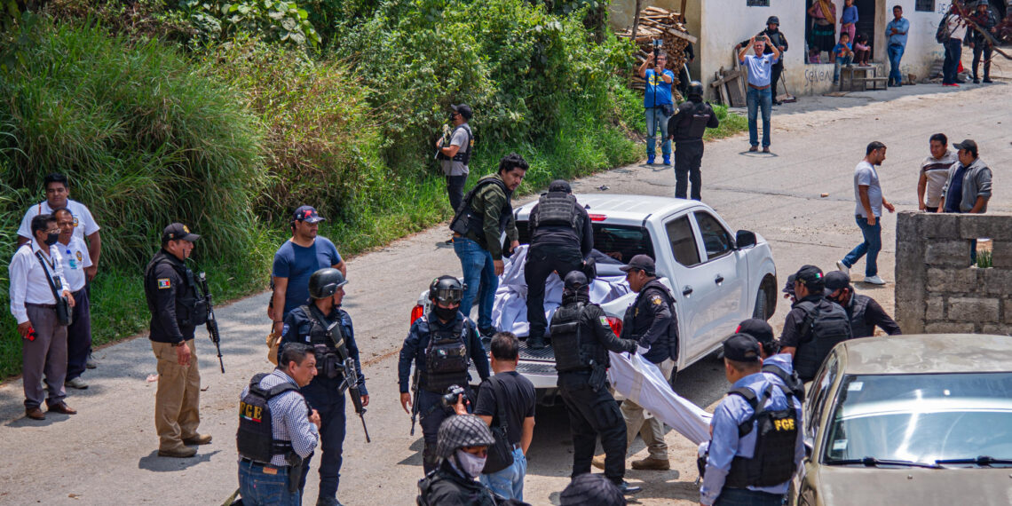 Miembros de la Policía Estatal y de la Fiscalía General del Estado levantan un cadáver junto a una camioneta con impactos de bala hoy, en el municipio de Chenalhó, estado de Chiapas, (México). EFE/ Carlos López