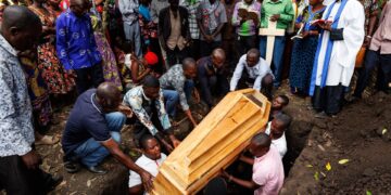 Personas bajan un ataúd a una tumba durante el funeral de una de las víctimas de un ataque en una escuela, en Mpondwe, Uganda, este 18 de junio de 2023. EFE/EPA/Luke Dray