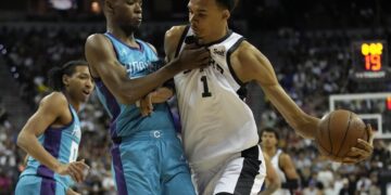 San Antonio Spurs' Victor Wembanyama, right, drives against Charlotte Hornets' Brandon Miller during the first half of an NBA summer league basketball game Friday, July 7, 2023, in Las Vegas. (AP Photo/John Locher)