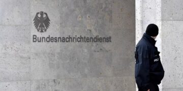 Un policía monta guardia junto al logotipo y el nombre del Servicio Federal de Inteligencia alemán (BND) (John MACDOUGALL / AFP)