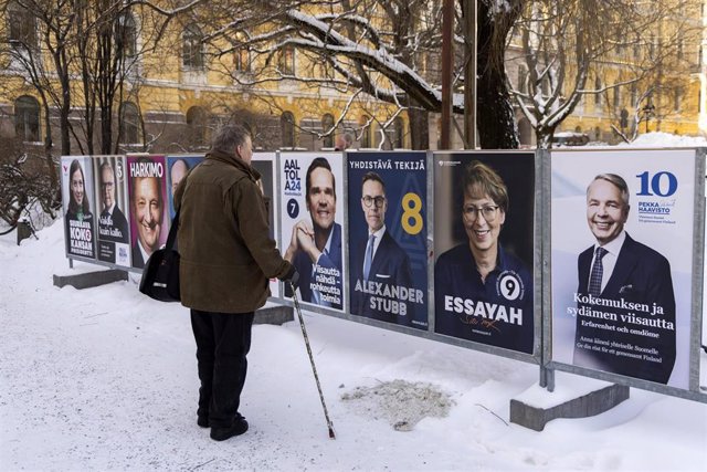 Ciudadano finlandés frente a carteles electorales de los candidatos a la Presidencia de Finlandia - Europa Press/Contacto/Chen Jing