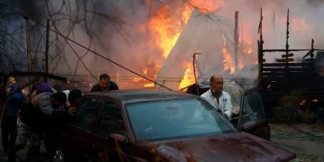 Residentes empujan un auto para alejarlo de las llamas de un incendio en Villa Alemana, Valparaíso, el 2 de febrero de 2024 (Andres Pina, Aton Chile vía AP)