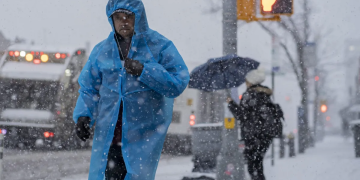 Transeúntes caminan en medio de una fuerte nevada este martes, en la ciudad de Nueva York (EE.UU.). EFE/ Ángel Colmenares