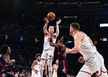New York Knicks' Donte DiVincenzo, left, passes to teammate Isaiah Hartenstein, front, during the first half of an NBA basketball game in New York, Monday, March 25, 2024. (AP Photo/Peter K. Afriyie)