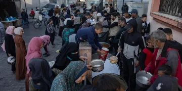 Palestinos desplazados se aglomeran por comida en Paso de Rafah. Foto de EFE/EPA/HAITHAM IMAD