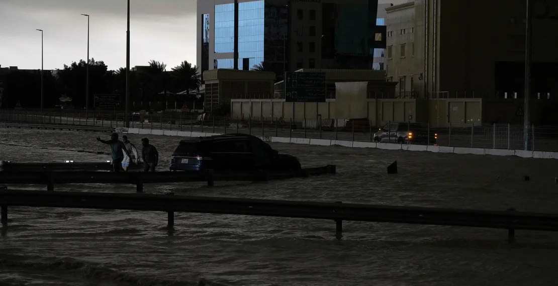 Hombres intentan remolcar un vehículo para sacarlo del agua estancada en Dubai, Emiratos Árabes Unidos, el martes. (Jon Gambrell/AP)