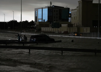 Hombres intentan remolcar un vehículo para sacarlo del agua estancada en Dubai, Emiratos Árabes Unidos, el martes. (Jon Gambrell/AP)