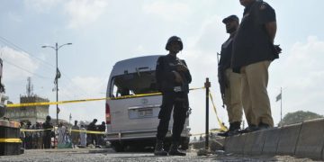 Agentes de policía hacen guardia junto al escenario de un ataque suicida en Karachi, Pakistán, el 19 de abril de 2024. (AP Foto/Fareed Khan)