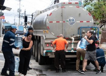 Unos vecinos de un barrio de San José recolectan agua de un camión cisterna el 26 de enero de 2024 © Ezequiel Becerra / AFP/Archivos